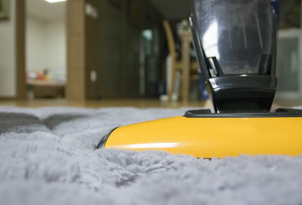 vacuum cleaner working on a carpet as one of the methods to get dog hair out of carpets